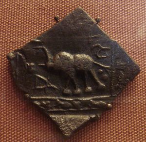 Coins produced in the Satvahana Empire sometimes had inscriptions in Prakrit on one side and Tamil on the other.  This lead coin shows a bull with inscriptions in Bramhic script.